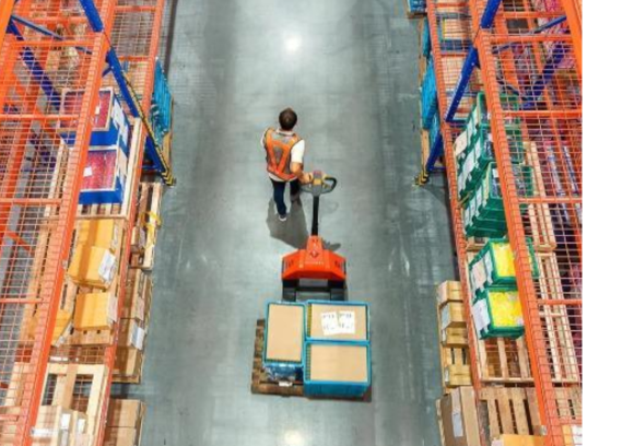 Warehouse worker moving pallets with a pallet jack